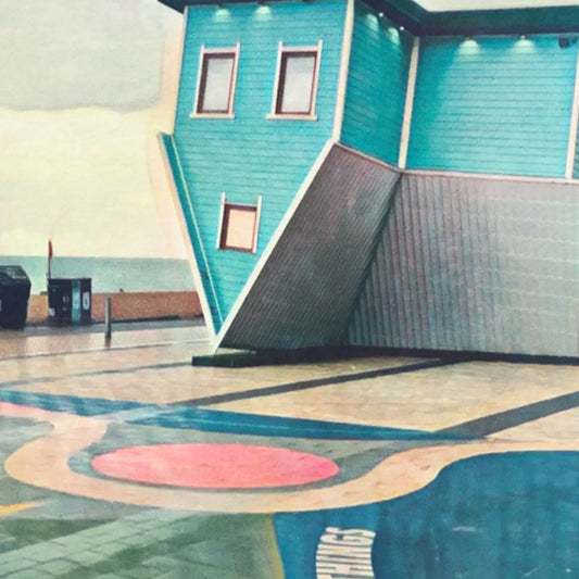 Close-up of Brighton Upside Down House poster showing halftone grain, pastel colours, and inverted architecture