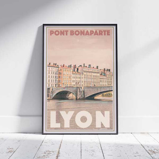 Framed Lyon Pont Bonaparte travel poster on white wooden floor showcasing French cityscape art