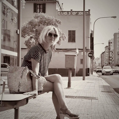 Black and white portrait of Cha, illustrator and co-founder of Myretroposter, sitting in Palma de Mallorca. A mother and retro poster artist known for collections like Soft Pop Studio™, Vintage Exotics™, and The Great Indian Décor™