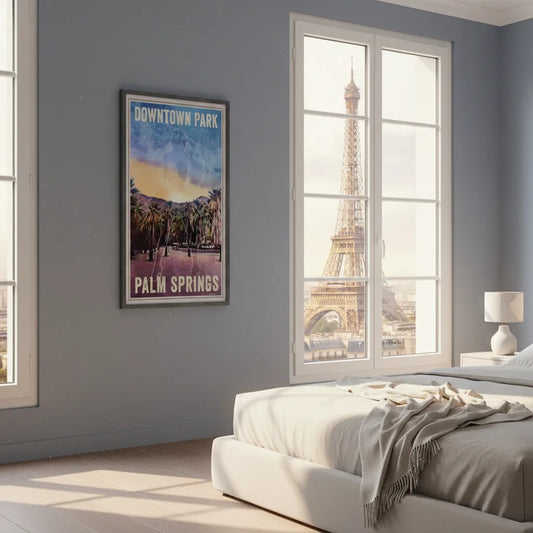 Interior scene featuring the Palm Springs Beyond Monuments poster by Alecse, framed on a wall in a minimalist bedroom, with natural light and a window view of the Eiffel Tower