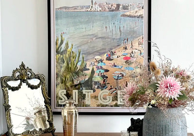 Cala Balmins Sitges limited edition poster by Alecse styled with vintage decor and floral arrangement