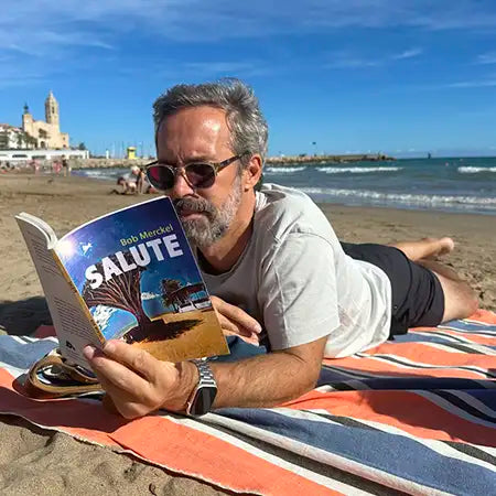 Alecse reading the book “Salute” by Bob Merckel, featuring the cover illustration he designed.