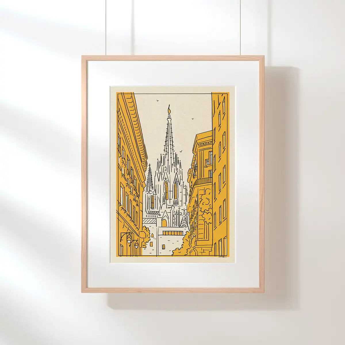 Barcelona Cathedral poster by Cha, displayed in a natural wood frame with a warm yellow architectural illustration.