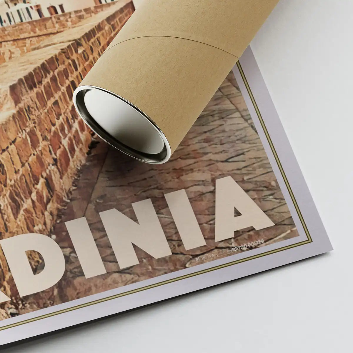 Detail of Alghero Sardinia poster corner with artist signature, shown next to an eco-friendly shipping tube