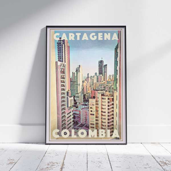 Framed Cartagena Colombia Travel Poster on a white wooden floor, showcasing a vibrant city skyline in pastel hues. Limited edition, 300 copies
