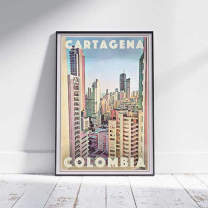 Framed Cartagena Colombia Travel Poster on a white wooden floor, showcasing a vibrant city skyline in pastel hues. Limited edition, 300 copies