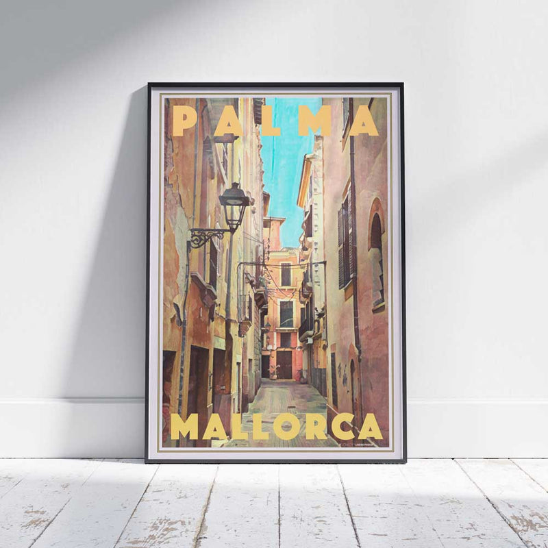 Framed Palma Valero Travel Poster on a white wooden floor, featuring a serene Mediterranean street in Palma’s Old Town. Limited edition, 300 copies