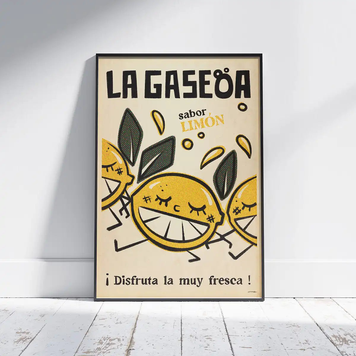La Gaseoa Limón poster by Cha framed on white wooden floor, featuring smiling lemons and retro typography in yellow and green