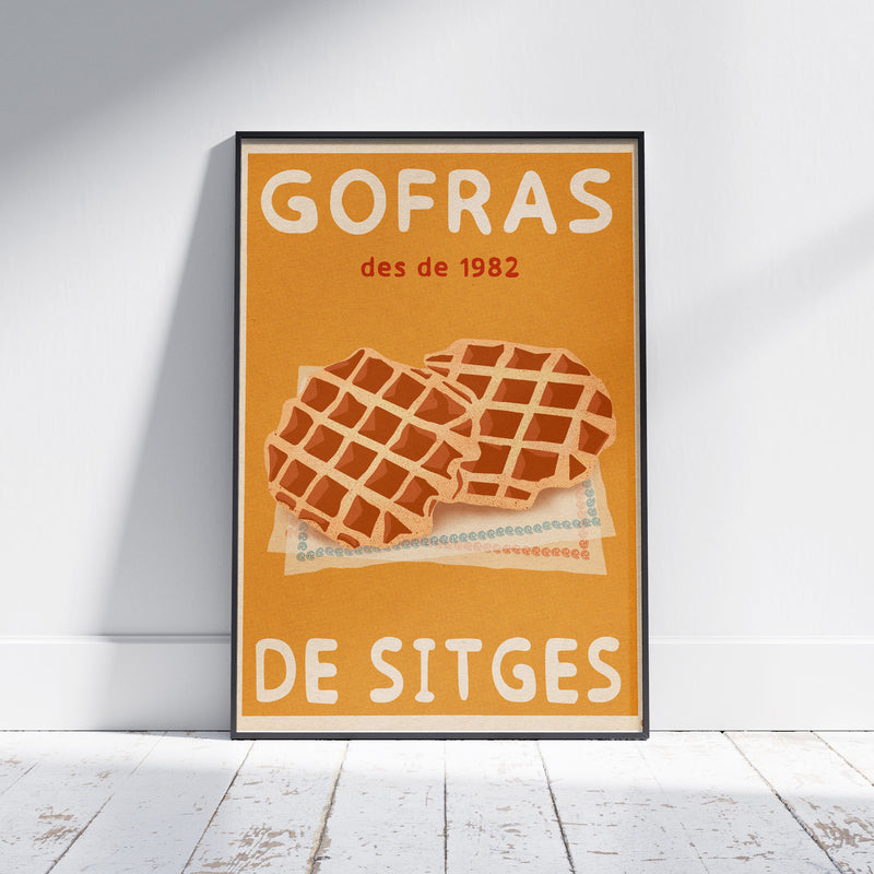Sitges Waffles Poster by Cha framed on a white wooden floor, showing two golden waffles on patterned napkins over an ochre background. Retro halftone texture visible. Limited edition of 300 prints.