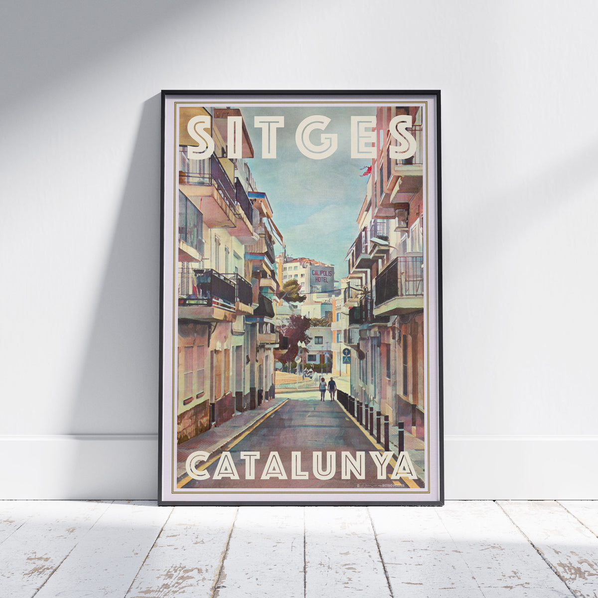 Framed Sitges Calipolis poster by Alecse showing a sunlit Catalan street leading toward the Calipolis Hotel in vintage tones.
