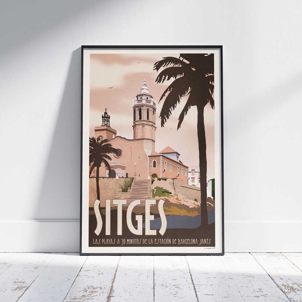 Sitges Rose vintage travel poster framed and leaning against a white wooden floor, featuring the Church of Sant Bartomeu i Santa Tecla in soft pink tones.