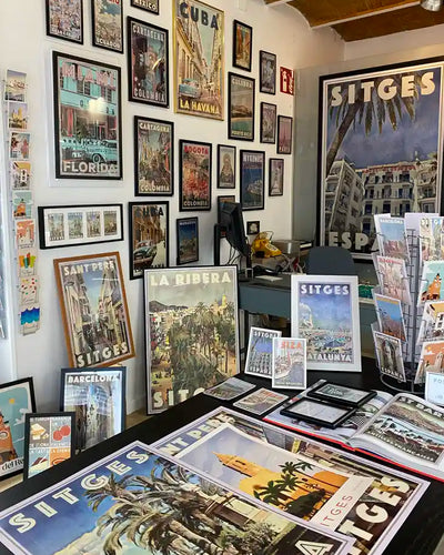 Inside La Galerie by Myretroposter in Sitges, showcasing a vibrant collection of vintage travel posters and retro wall art prints from destinations worldwide. Framed and unframed prints fill the space, featuring iconic locations like Sitges, Barcelona, Cuba, Miami, and more. The gallery’s carefully curated displays highlight the timeless appeal of Alecse’s limited-edition travel artwork, offering a unique selection of posters and postcards