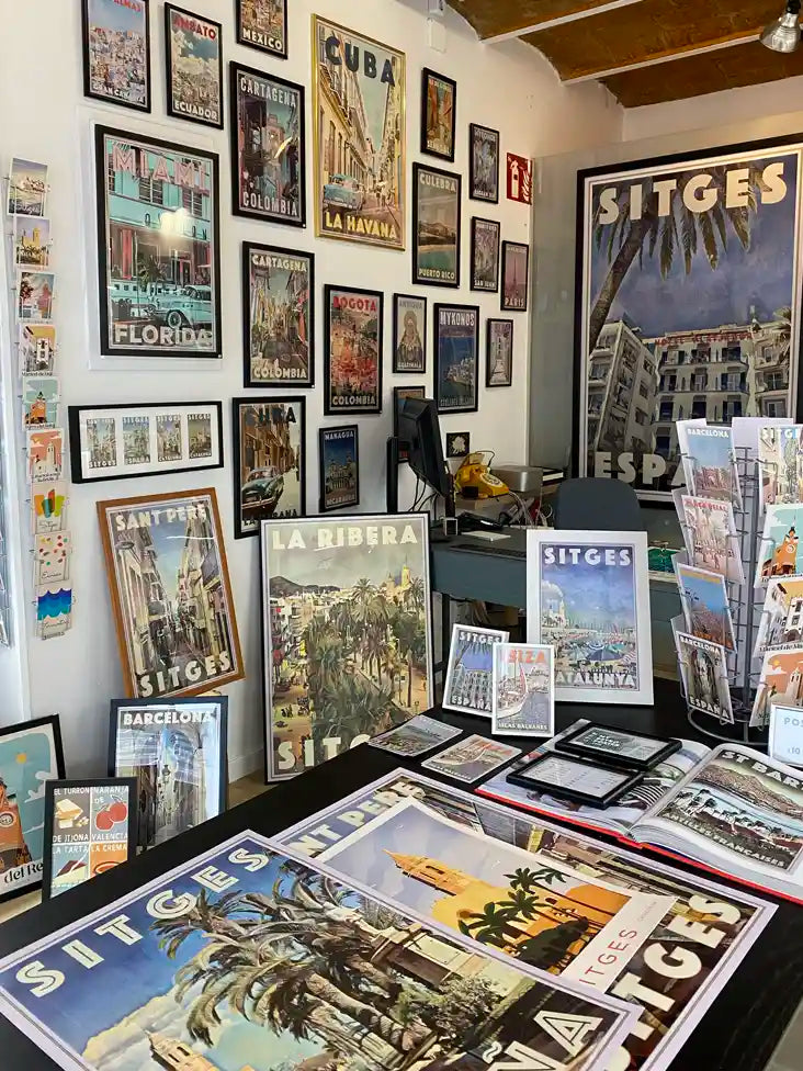 Inside La Galerie by Myretroposter in Sitges, showcasing a vibrant collection of vintage travel posters and retro wall art prints from destinations worldwide. Framed and unframed prints fill the space, featuring iconic locations like Sitges, Barcelona, Cuba, Miami, and more. The gallery’s carefully curated displays highlight the timeless appeal of Alecse’s limited-edition travel artwork, offering a unique selection of posters and postcards