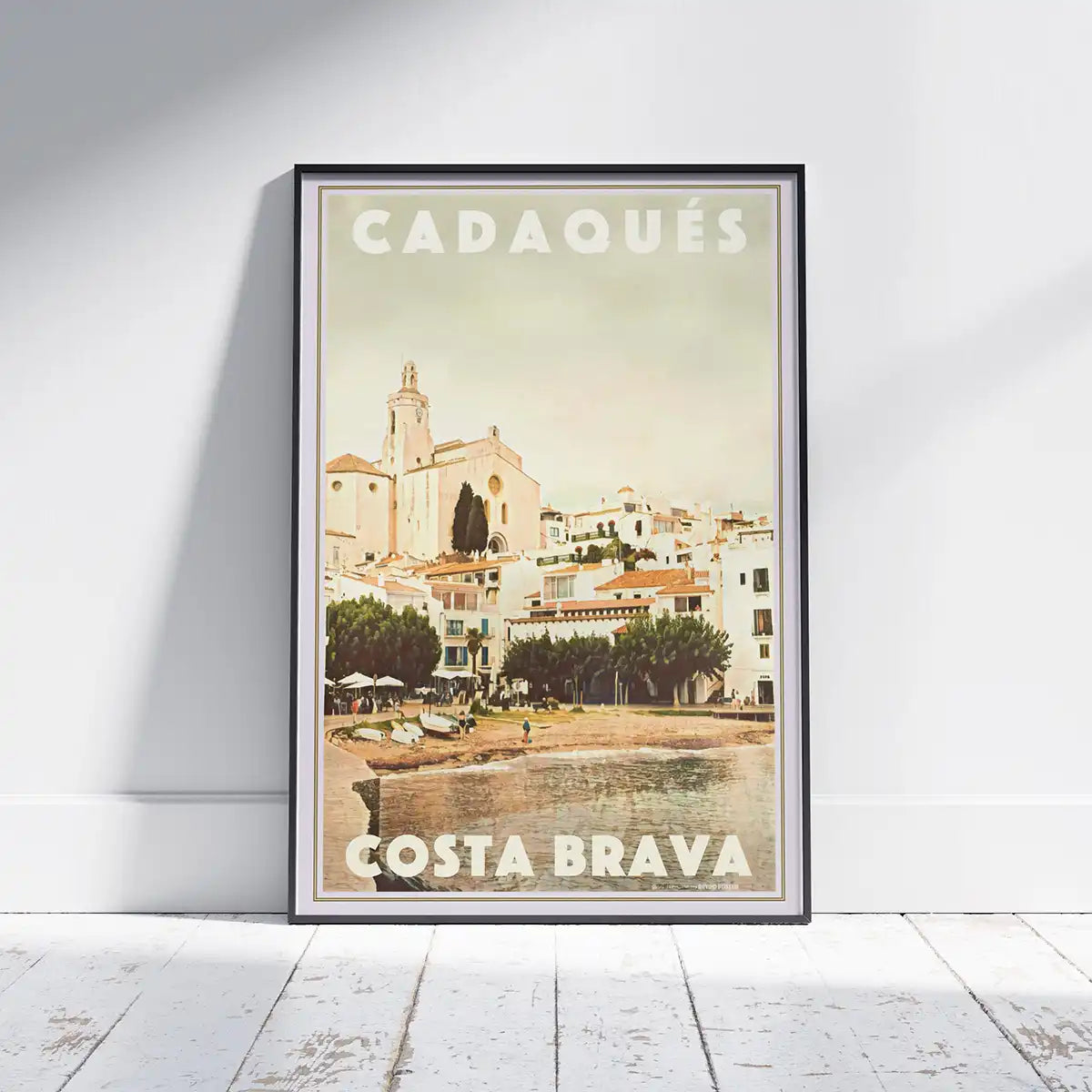 Cadaqués Church vintage travel poster framed on wall, featuring Santa Maria church overlooking the Costa Brava waterfront