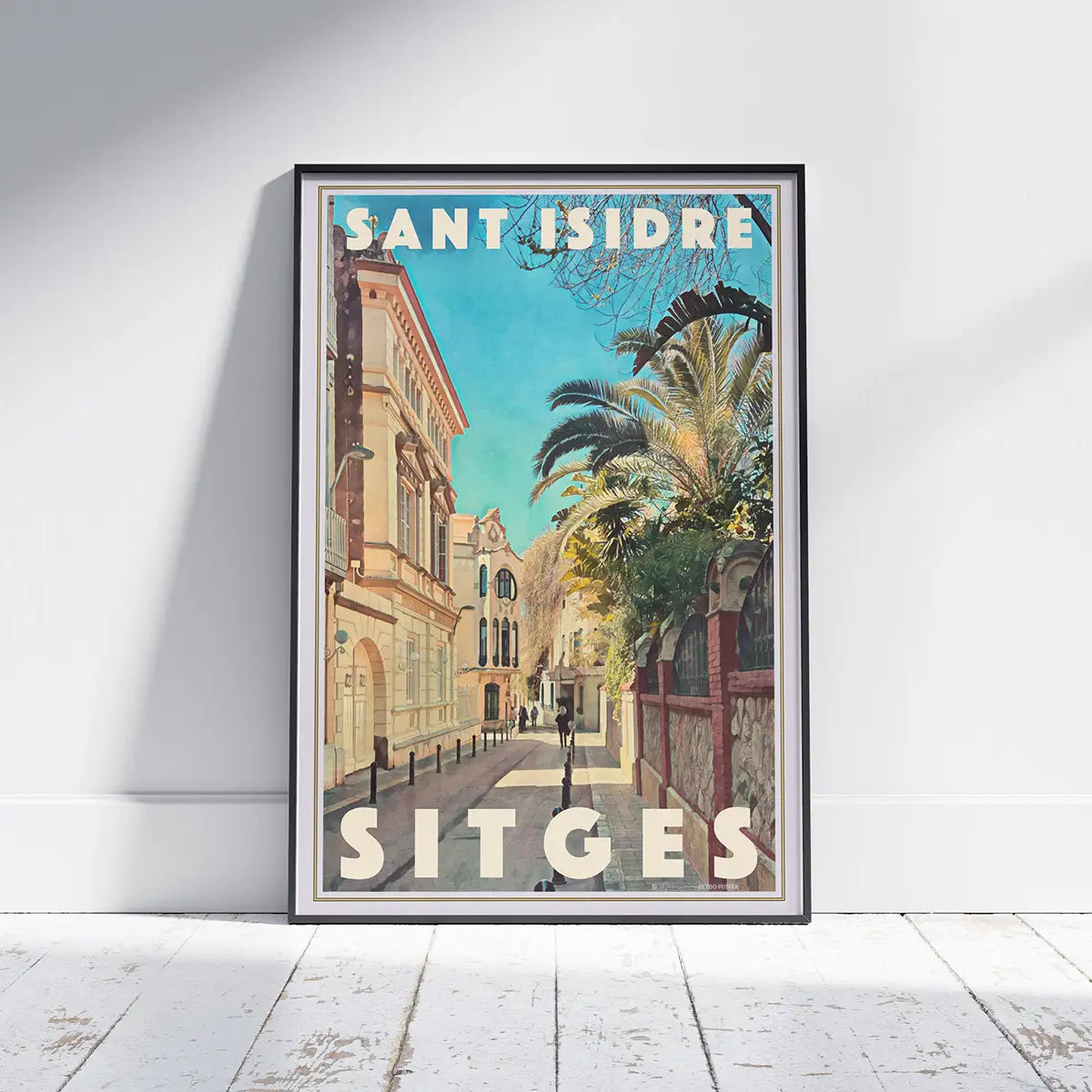 Sant Isidre Sitges vintage travel poster framed on floor, sunny Mediterranean street with palm trees and pastel buildings, limited edition wall art