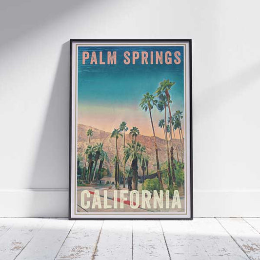 Framed Palm Springs Sunrise Travel Poster on a white wooden floor, highlighting the vibrant colors and serene landscape