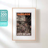 Framed 'City of Life' poster in hanging display, a limited edition art piece depicting Bangkok's Soi 19 by Alecse